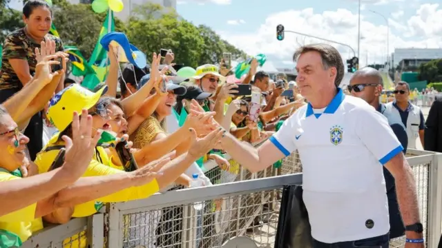 Bolsonaro aparece cumprimentando dezenasfree spin slotomaniaseguidores do outro ladofree spin slotomaniacerca, vários deles com as mãos estendidas