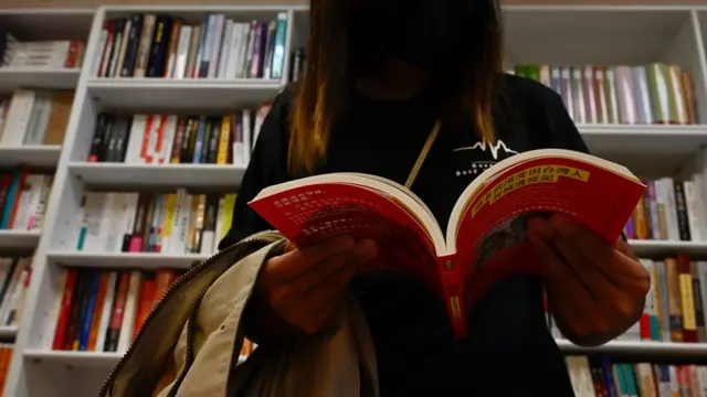 一位女士在书店内阅读台湾社运书籍