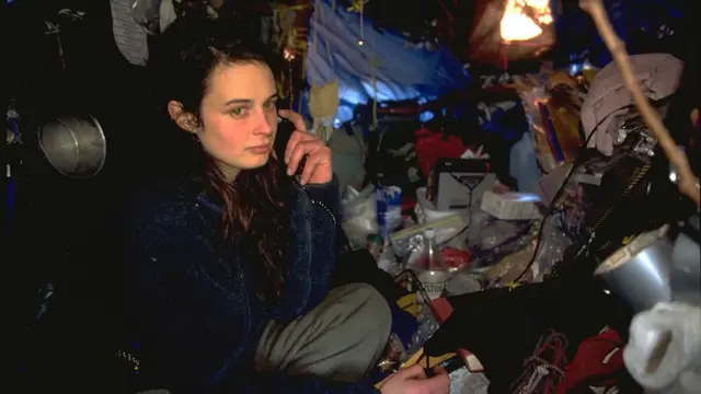 Julia Butterfly Hill hablando por un teléfono celular dentro de su refugio en el árbol