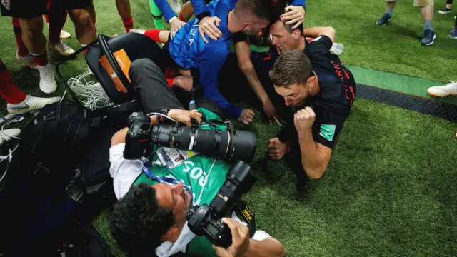футболисты падают на фотографа