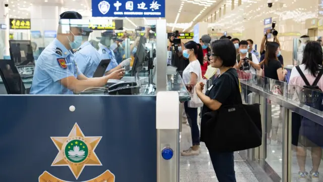 澳門特區政府治安警察局人員(左)在橫琴口岸新旅檢區域模擬通關演練中為旅客辦理過關手續(新華社圖片17/8/2021)