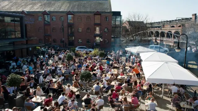 مجموعة من الناس يجلسون في مقهى في الشارع