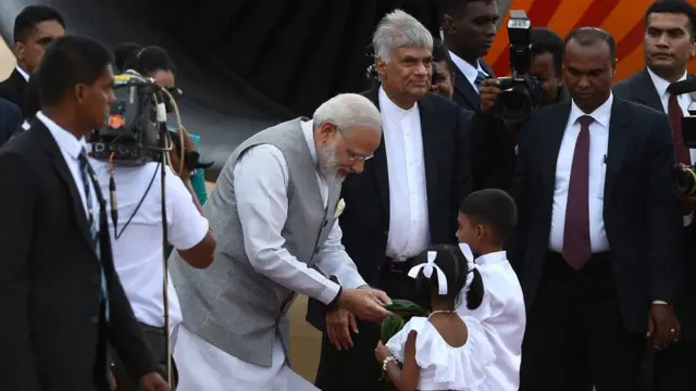 India's Prime Minister Narendra Modi (C) is watched by Sri Lankan Prime Minister Ranil Wickremesinghe (R) and other officials after signing the 'Golden Book' after arriving at Bandaranaike International Airport in Colombo on May 11, 2017, for a visit to Sri Lanka. / AFP PHOTO / LAKRUWAN WANNIARACHCHI (Photo credit should read LAKRUWAN WANNIARACHCHI/AFP/Getty Images