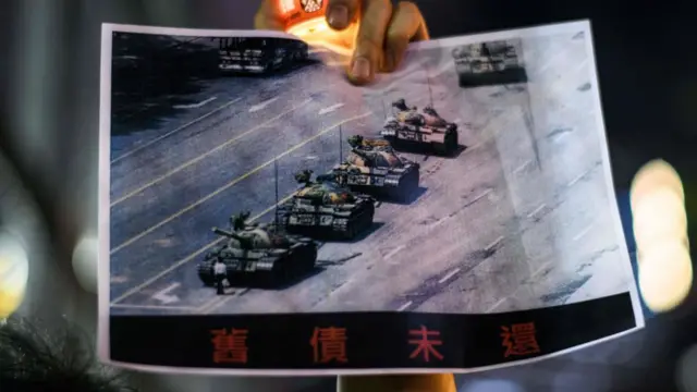 हॉन्ग कॉन्ग में प्रदर्शन के दौरान टैंक मैन की ऐतिहासिक तस्वीर दिखाता एक शख़्स