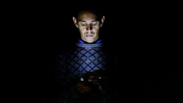 Homem iluminado pela luzseu telefone