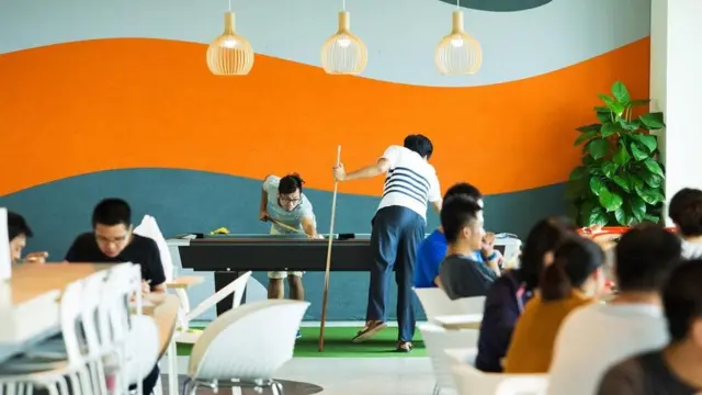 عاملون يمارسون لعبة البلياردو