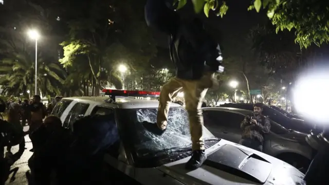 Homem depreda carro da polícia durante protesto