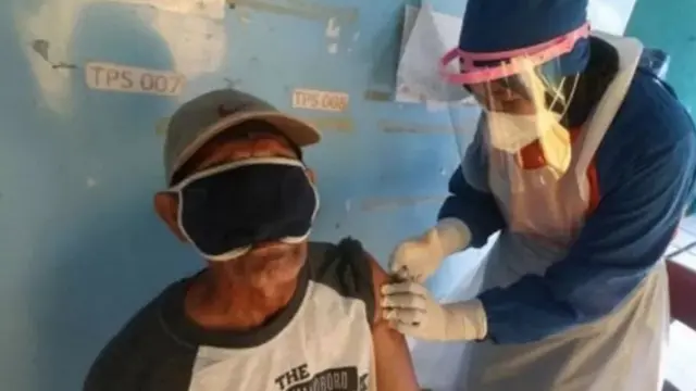 Petugas kesehatan menyuntikkan vaksin COVID-19 kepada ketua RT di Kota Kediri, Jawa Timur, Rabu (17/03/21).