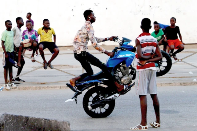 Un jeune homme se produit sur une moto dans une rue d'Abidjan, en Côte d'Ivoire, le mercredi 28 juillet 2021.