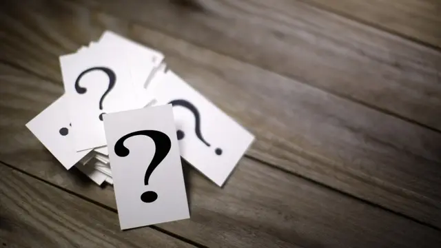 Concept photo - a pile of 'question mark' cards on a table
