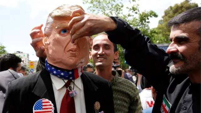 Iranian protesters against the US in Tehran, with one wearing a mask of US President Donald Trump
