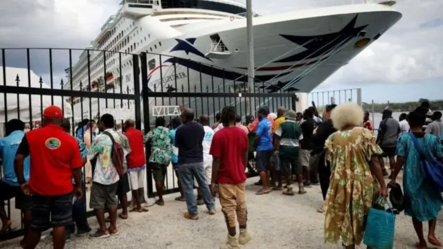 عمال محليون ينتظرون سفينة سياحية في فانواتو في ديسمبر/كانون الأول 2019