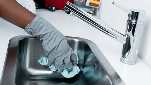 Person wey dey clean kitchen sink.