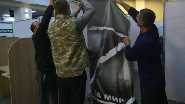 Люди вешают большой баннер