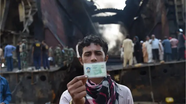 ایک مزدور کے لواحقین شناختی کارڈ دکھا رہے ہیں