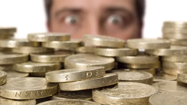 Hombre mirando monedas de libras esterlinas