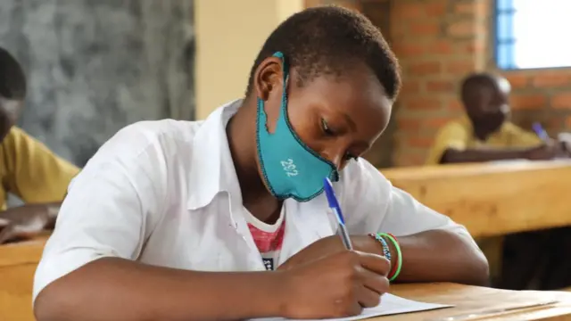 Umunyeshuri w'umukobwa urimo gukora ikizamini cya leta mu Rwanda ku itariki ya 12 y'ukwezi kwa karindwi mu 2021