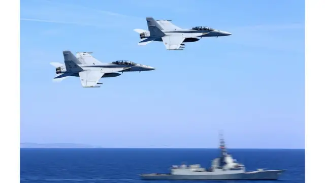 دو فروند F/A-۱۸F از اسکادران جولی راجرز در حال عبور از فراز ناو اسپانیایی محافظ ناوگروه یو اس اس آبراهام لینکلن، پانزده آوریل ۲۰۱۹