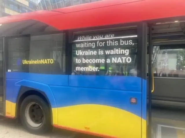 Литвадаги автобус деразасидаги ёзув: "Сиз бу автобусни кутиб турган чоғингизда Украина НАТОга аъзо бўлишни кутяпти".