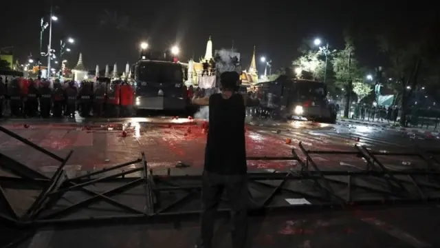 An anti-government protester faces the riot-police officers during march a rally calling to revoke the lese majeste law, near the Grand Palace in Bangkok, Thailand, 13 February 2021.