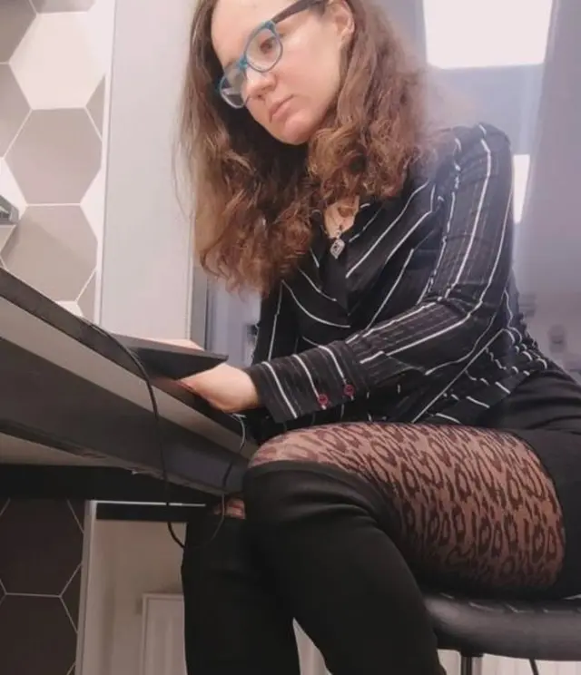Blogger Anna Arinarhkova wearing leopard skin tights sitting at a desk