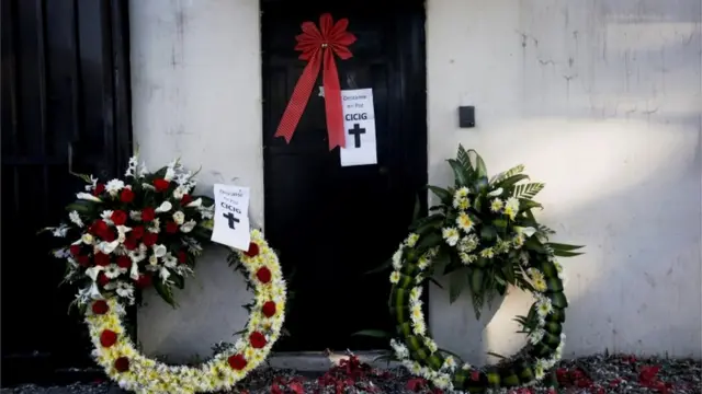 Coronas de flores y carteles con la leyenda "Cicig descanse en paz".