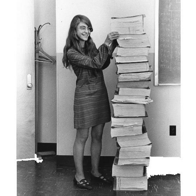 Margaret Hamilton junto a una pila de libros con programas de software escritos para la misión Apolo