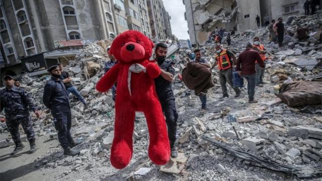 Un palestino con oso Teddy en medio de los escombros dejados por un ataque aéreo en Gaza.