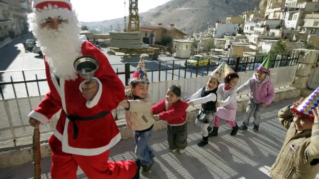 Noel baba kostümlü bir kişi, Şam'ın kuzeyindeki Hristiyan kasabası Maalula'da çocuklarla oynuyor