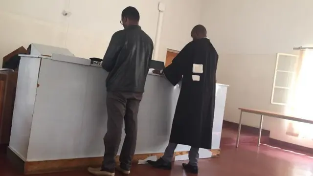 Robert Bayigamba (ibumoso) n'umwunganizi we mu mategeko, mu cyumba cy'urukiko