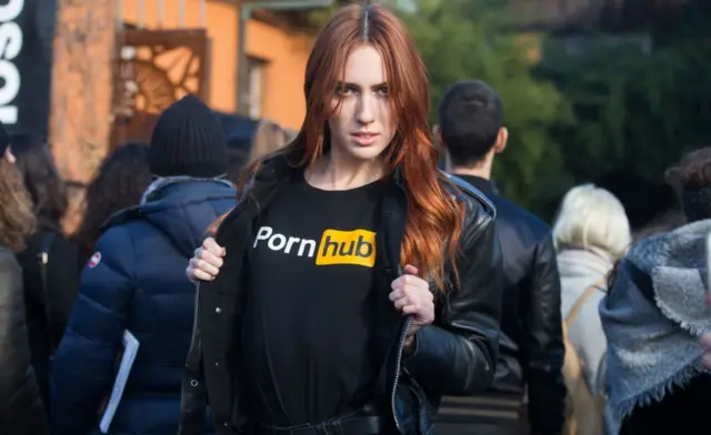 Modelo posa para foto com camisa estampada com logo do Pornhub