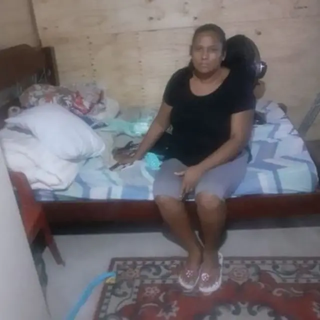 Valdirene sentada na cama