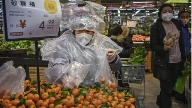 वुहान में सब्ज़ी बेचती एक महिला