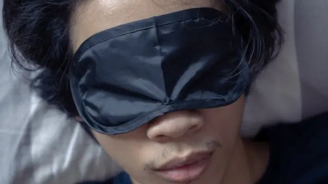 Homme dormant avec un masque