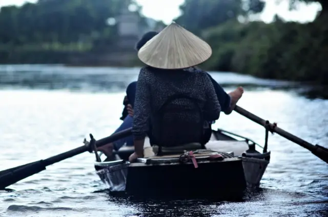 رجال ونساء في فيتنام يطوفون بالسياح في نينه بيه