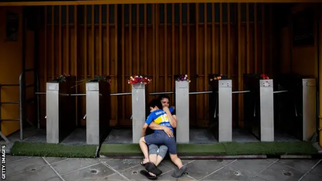 A mother and son mourn Maradona outside La Bombonera