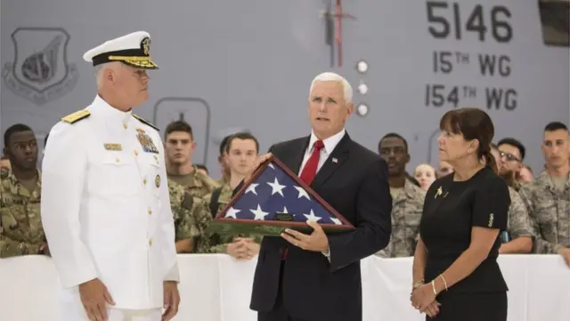 Pence segura uma bandeira americana dobrada enquanto recebe os restos mortaisbuffalo betsoldados americanos