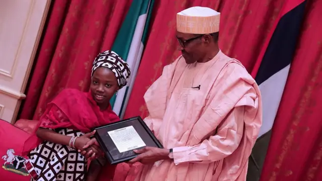 Aisha 'yar shekara 10 tana karbar kyautar daga hannun Shugaba Buhari