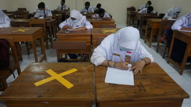 Siswa kelas IX SMP Negeri 9 Solo sedang mengikuti pembelajaran tatap muka. Masing-masing tempat duduk siswa diberi jarak.