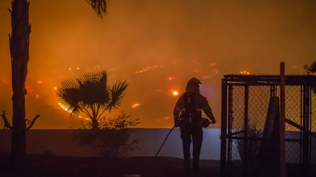 Bombero observa el panorama de uno de los incendios en el sur de California