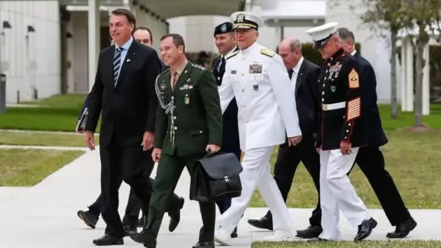 Homens idosos e um jovem, algunsis aviator on 1xbetuniforme militar, caminham ao ladois aviator on 1xbetBolsonaro