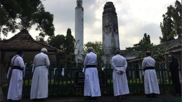 සුදු රිබන් ගැට ගසන ක්රිස්තියානි පූජකවරු