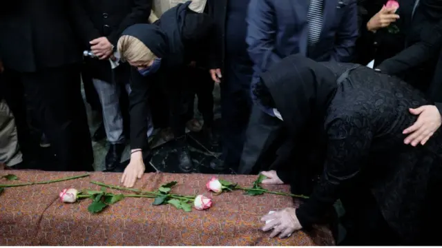 نسرین شجریان (سمت راست) بر جنازه برادرش محمدرضا شجریان دعا می‌خواند