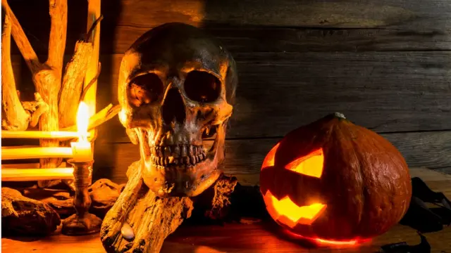 Череп и тыква на фоне камина