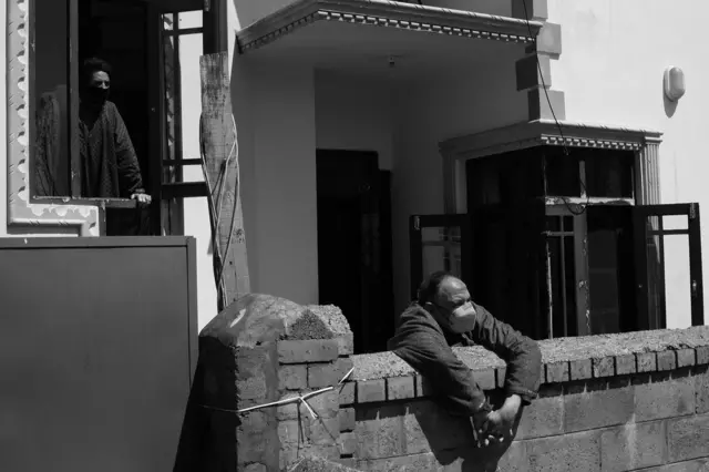 گھر سے باہر جھانکتا شخص