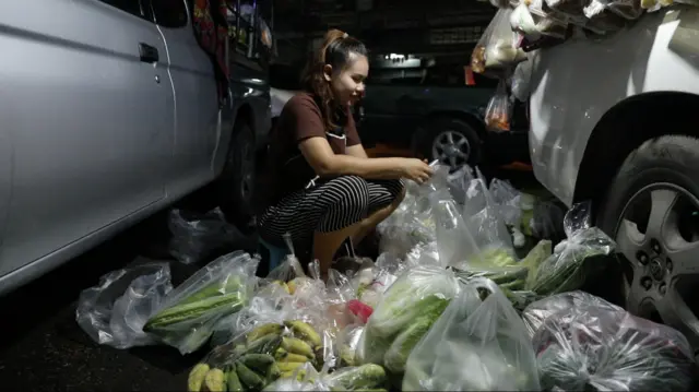 ประภัสสร โศกค้อ แยกอาหารสดใส่ถุงพลากสติกพร้อมเขียนราคา โดยใช้พื้นที่ลานจอดรถของตลาดบางแคเป็นพื้นที่ก่อนที่เริ่มออกขายของในแต่ละวัน