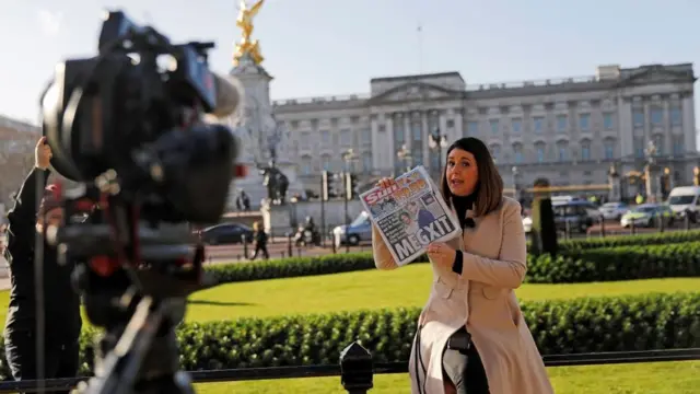 Una reportera informa sobre el anuncio de Meghan y Harry frente al Palacio de Buckingham