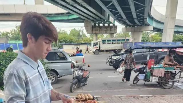 ผู้ชายยืนขายของ