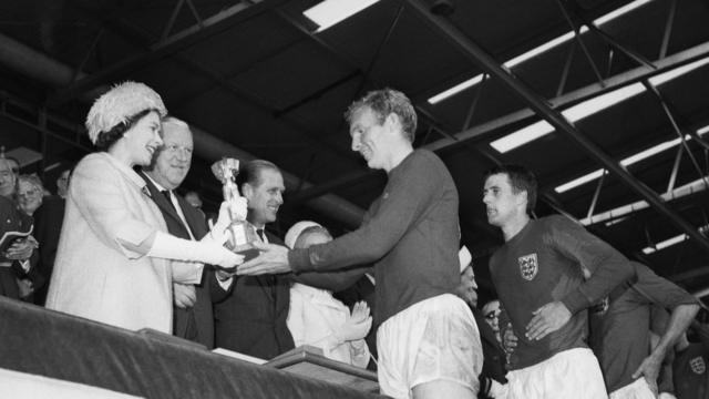 Queen Elizabeth II of Great Britain presenting the Jules Rimet trophy to the England captain, Bobby Moore, after the teams World Cup final victory over West Germany