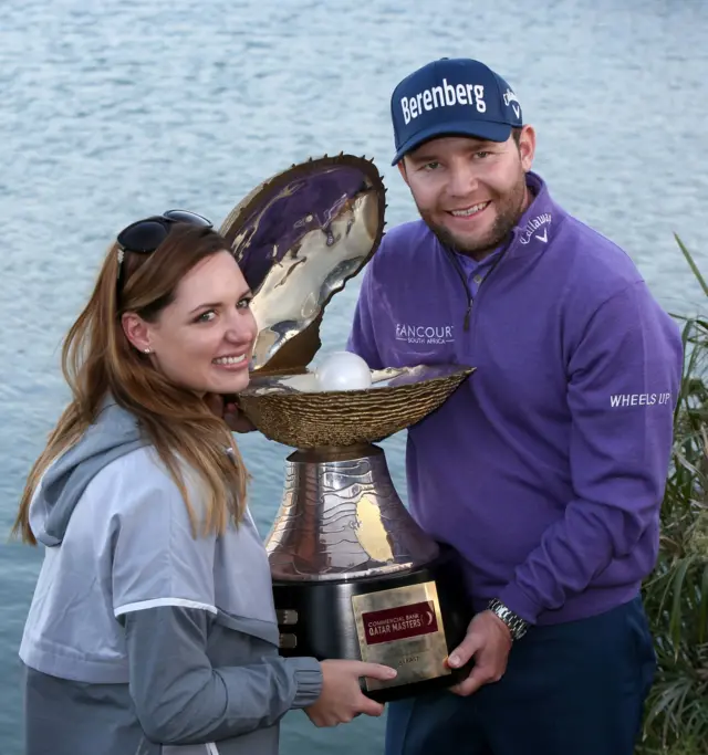 Golfista con un trofeo con forma de ostra